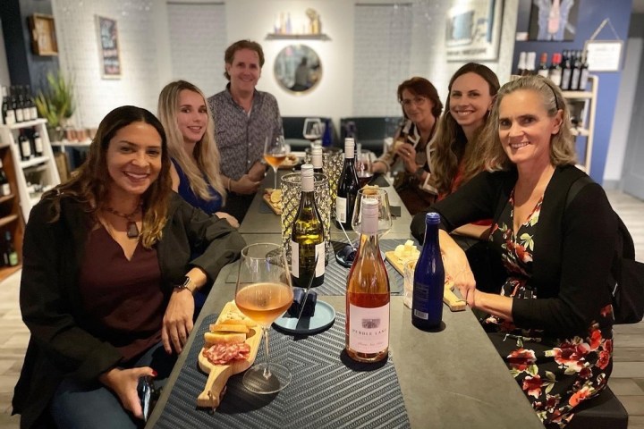 a group of people sitting at a table with wine glasses