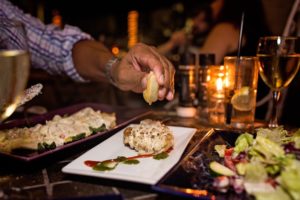 a person sitting at a table with a plate of food