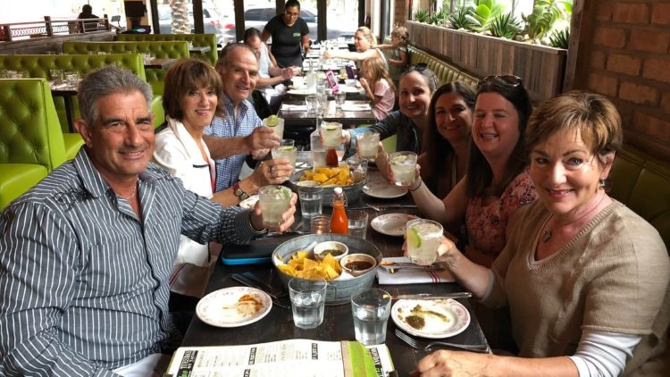 a group of people sitting at a table with food