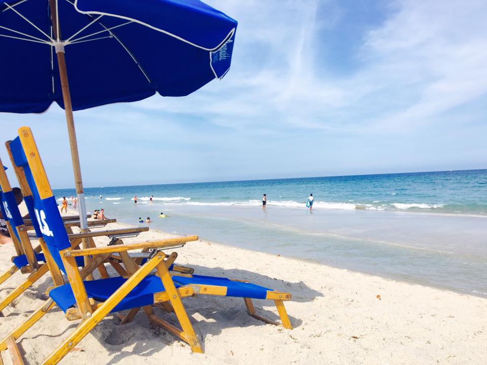a group of lawn chairs sitting on top of a sandy beach