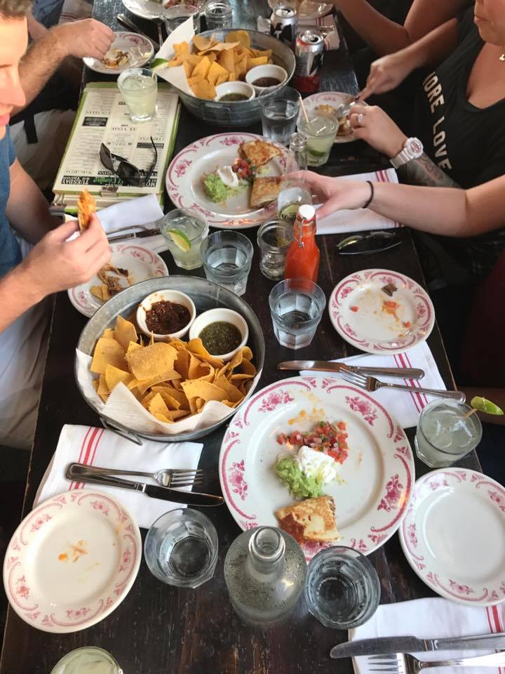 a group of people sitting at a table with a plate of food