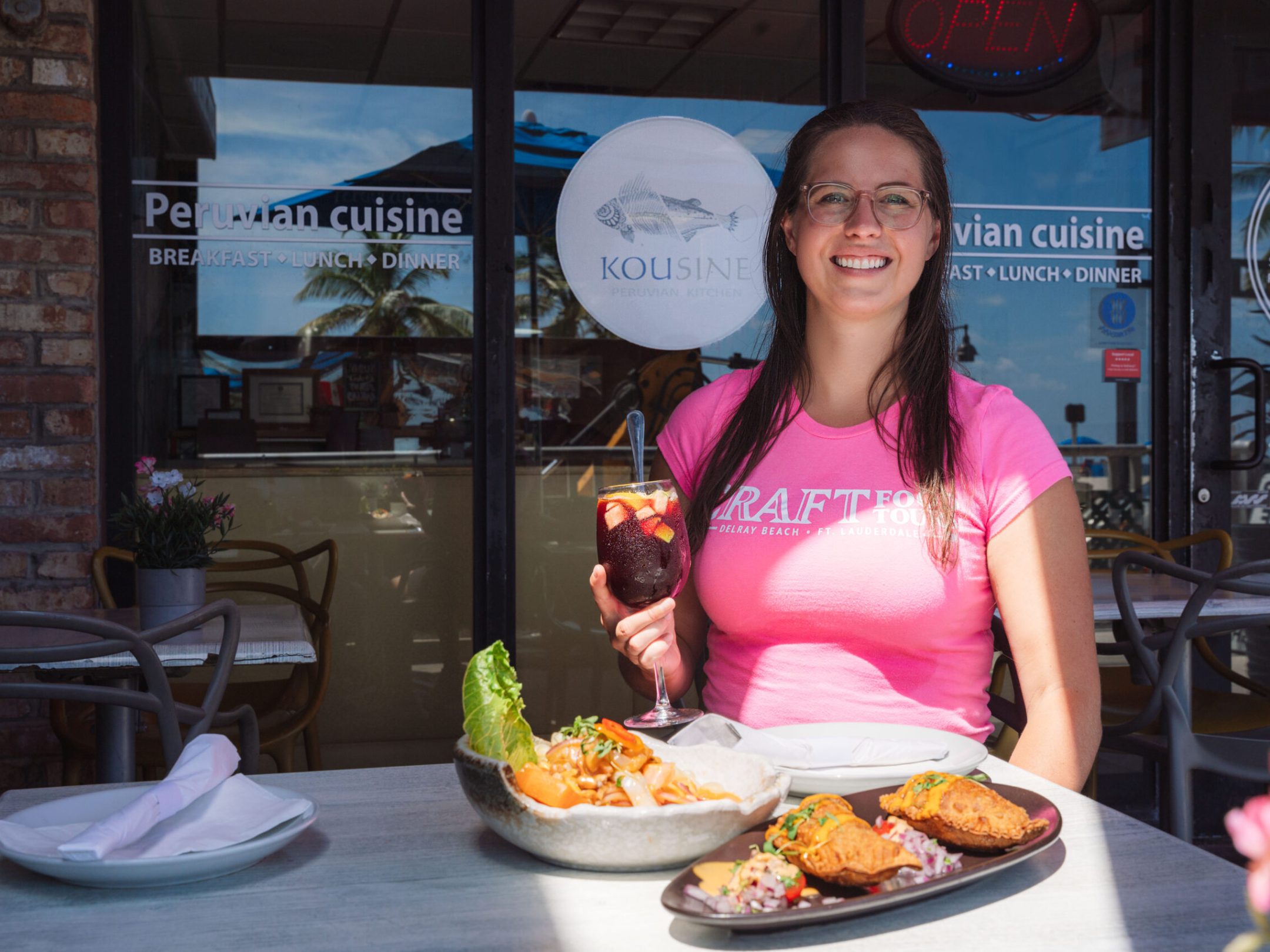 a woman sitting at a table with a plate of food