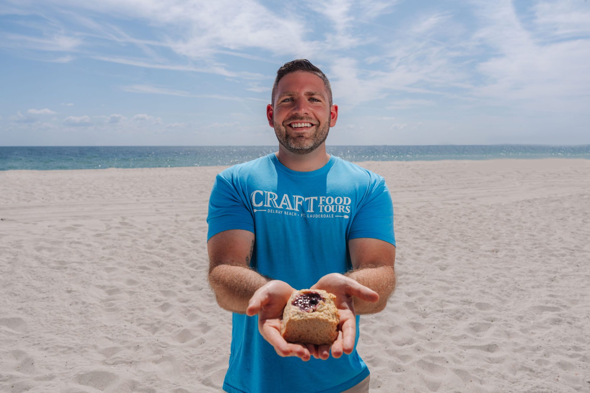 a man in a blue shirt standing in front of a body of water