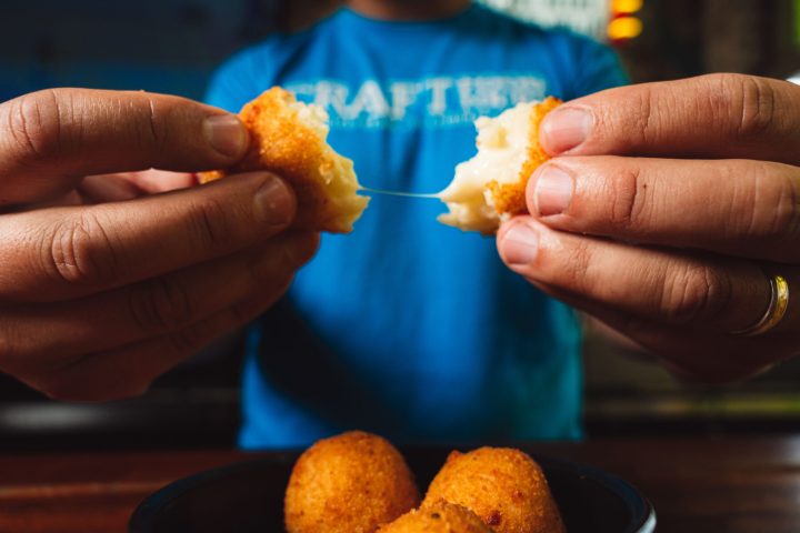 a hand holding a small piece of food