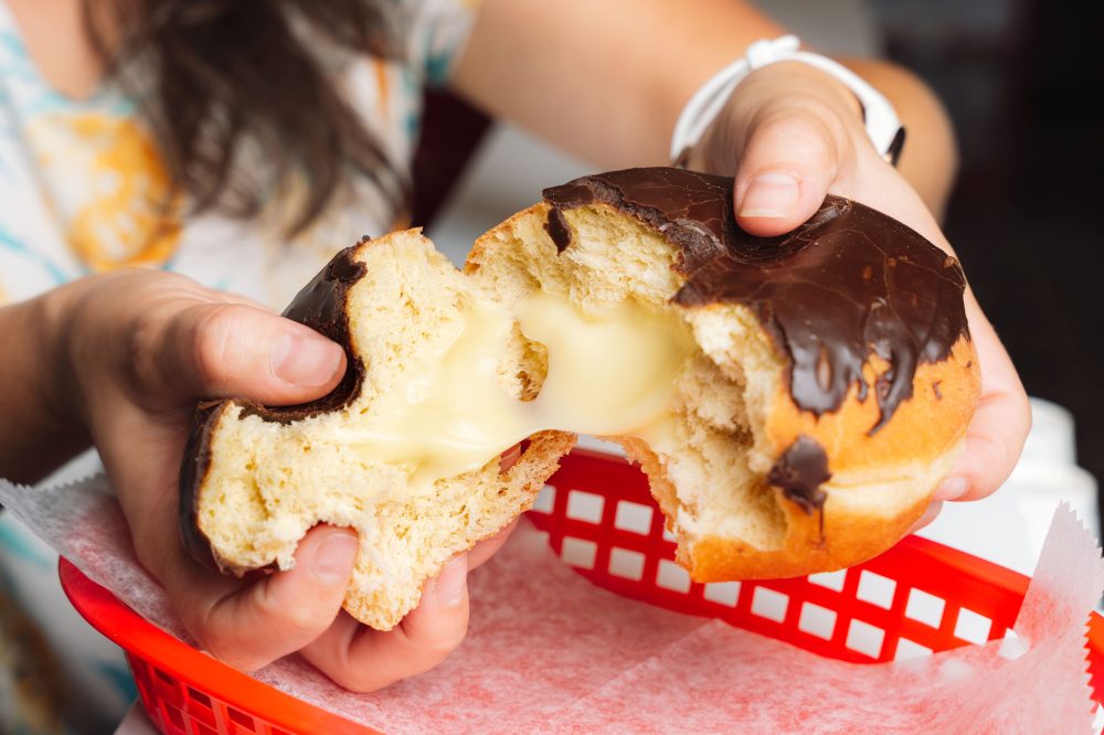 a person ripping open a donut from Hollywood Donut factory