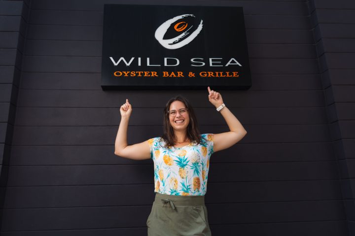 a woman standing in front of a brick wall